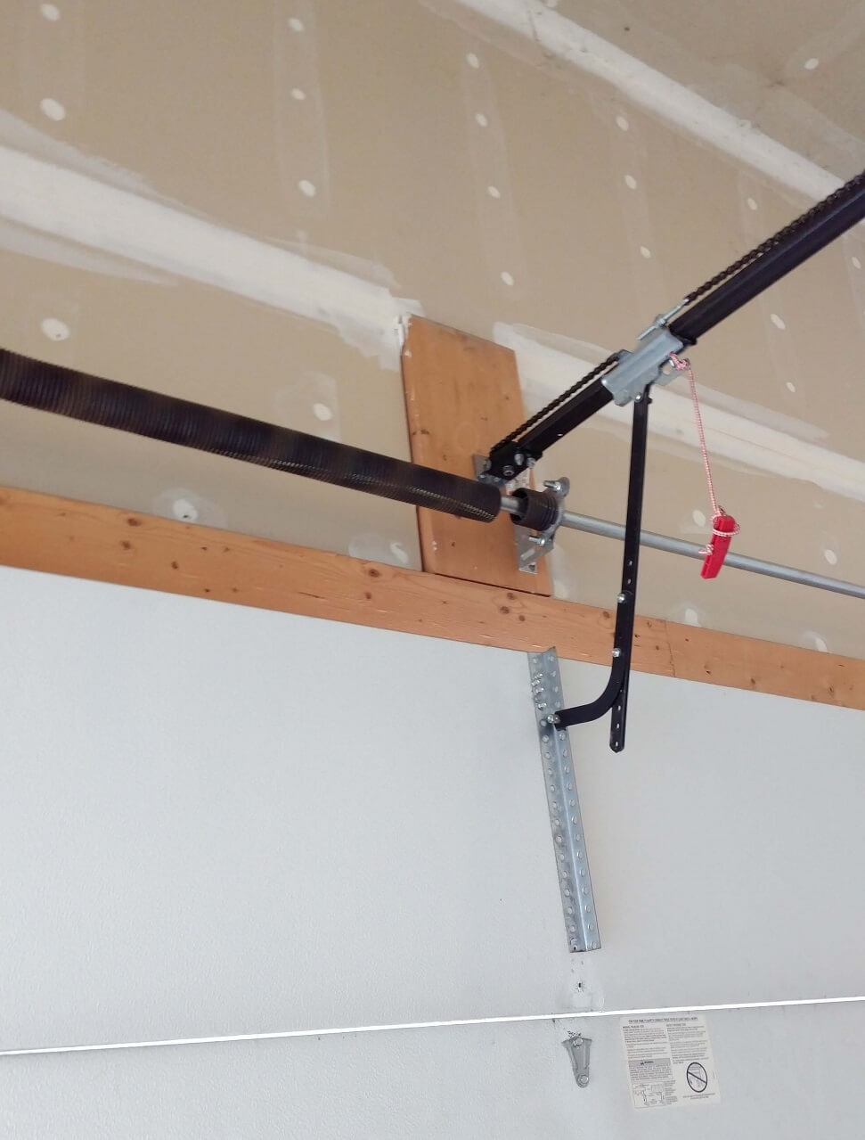 Close-up of a snapped garage door spring on the shaft