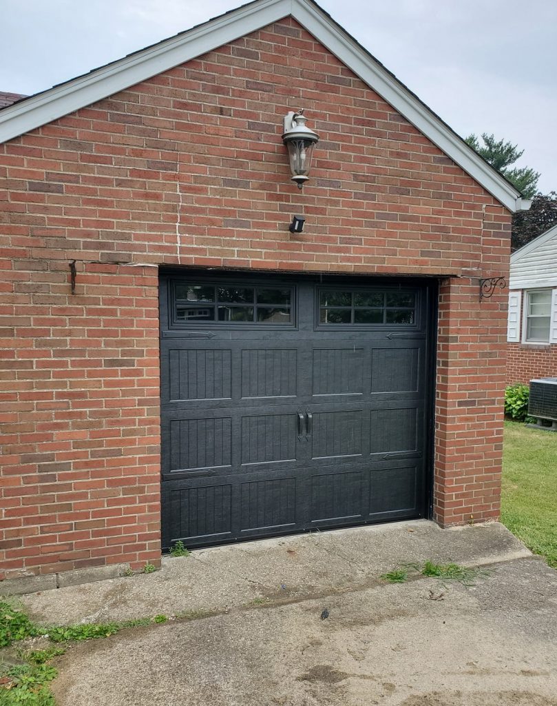 Black painted Carriage Style garage door with windows and hardware.